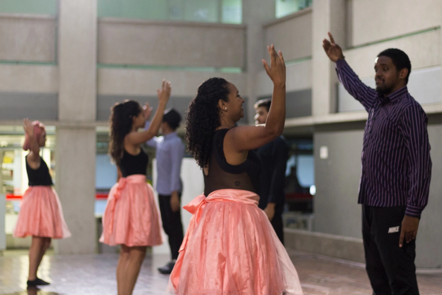 Dançarinos alinhados com as mãos para o alto na ETEC de Artes