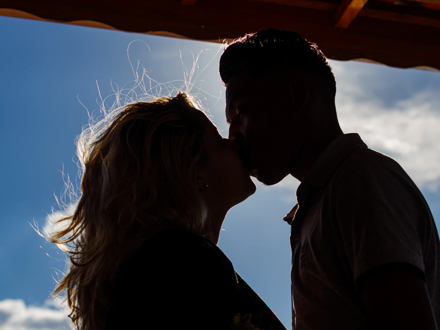 Um céu azul, um beijo e um casal feliz.